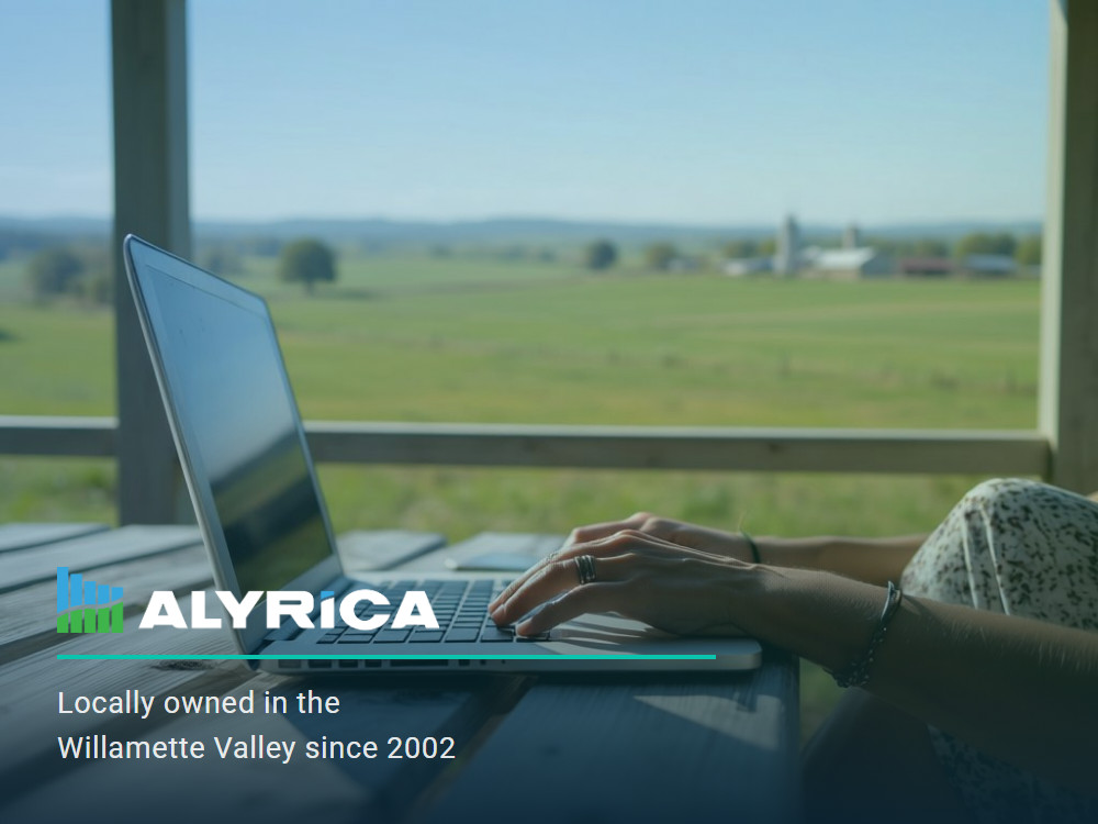 Alyrica logo with the tagline Locally owned in the Willamette Valley since 2002, over a photo of someone working on a laptop on a covered porch overlooking Willamette Valley farmland